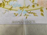 a close up of a napkin with a bird and flowers on it