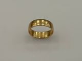 gros plan d'une bague en or sur une surface blanche