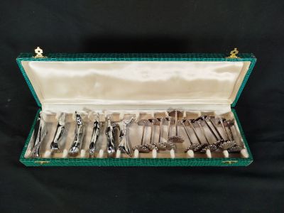 a green case with silverware in it on a black background
