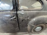an old car that has been rusted and is sitting in the garage