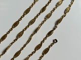 a close up of a gold chain on a white surface