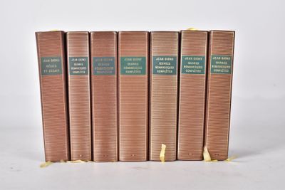 quatre livres sont alignés sur une surface blanche