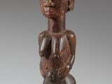 a close up of a wooden statue of a person with horns on his head