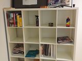 a white bookcase with many books on top of it