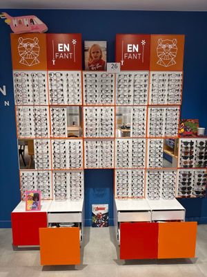 two rows of glasses on display in front of a blue wall