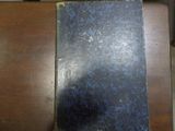 un livre bleu posé sur une table en bois, avec une souris dessus