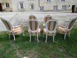four chairs are sitting in the grass in front of a building