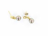 une paire de boucles d'oreilles en perles et or sur fond blanc