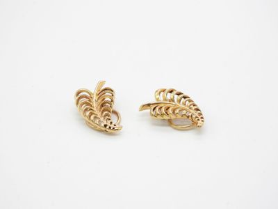 a pair of gold earrings with a leaf design
