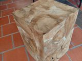 a wooden box sitting on a brick floor next to a dresser