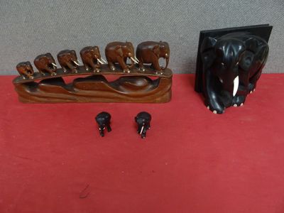 des sculptures d'éléphants posées sur une table rouge recouverte d'une nappe rouge