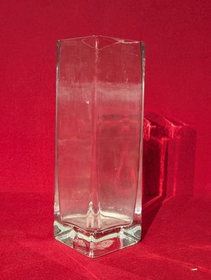 un vase en verre posé sur un tissu rouge