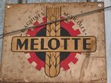 a metal sign hanging on the side of a building