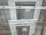 a stack of windows in a warehouse with plastic covering them