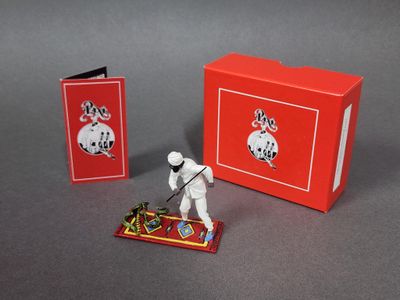 une figurine posée devant une boîte rouge