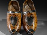 pair of wooden clogs with hearts on them on a gray surface