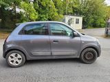 a small grey car parked in a parking lot