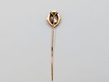 a close up of a gold broochle with a flower on it