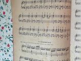 an open book with music notes on it sitting on a table