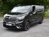 La camionnette noire est garée sur le parking, près des arbres.
