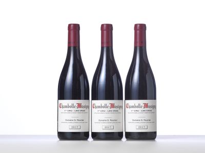 three bottles of red wine sitting on top of a table