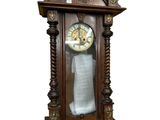 une grande horloge en bois accrochée au mur