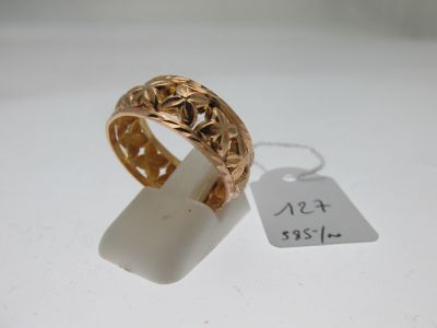 une image d'une bague en or sur une surface blanche avec une étiquette de prix