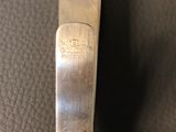 a close up of a metal tie bar on a leather surface