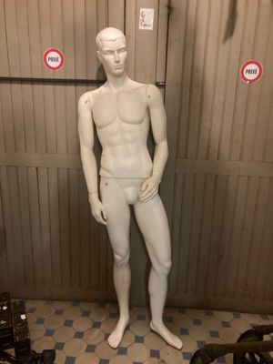 a white mannequin standing in a room with a checkered floor