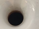 a white vase with a black hole in it