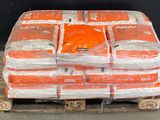 many bags of orange shirts on a pallet in a warehouse