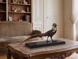 une statue représentant un faisan posée sur une table basse dans un salon