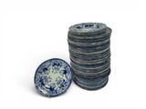 a stack of blue and white plates next to a stack of blue and white plates