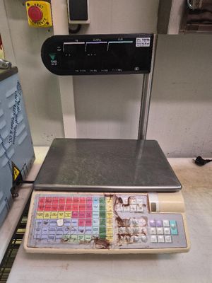 une balance posée sur un comptoir, avec une calculatrice devant