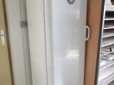 un réfrigérateur blanc dans le coin d'une pièce