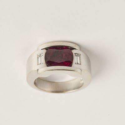 une image représentant une bague sertie d'une pierre rouge et de diamants