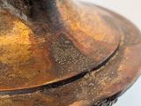 a close up of a bronze vase with a white background