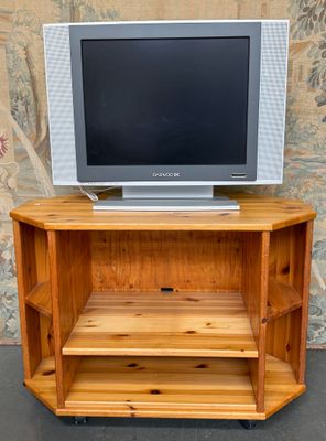 un téléviseur posé sur un meuble en bois devant un mur
