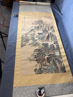 une photo d'un tableau posé sur une table, avec un appareil photo à côté