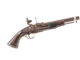 un vieux fusil exposé sur une surface blanche