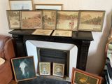 many framed pictures on the mantle in this living room