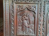 carvings of a man and a woman on a carved wooden cabinet