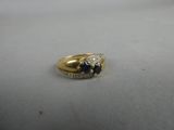 un gros plan d'une bague en or sertie d'un saphir et de diamants