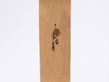the skateboard is made of wood and has a black writing on it