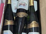 several bottles of wine are in a cardboard box on a table