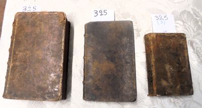 trois vieux livres posés sur une table l'un à côté de l'autre