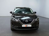 the front view of a black nissan vehicle in a showroom