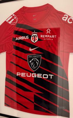 a framed picture of a red and black soccer jersey