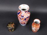 three vases sitting next to each other on a black surface
