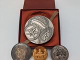 trois pièces d'argent et d'or dans une boîte rouge posée sur une surface blanche